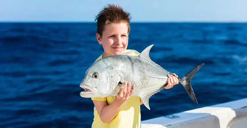 Boy with a fish on a reef fishing tour in Vilamoura