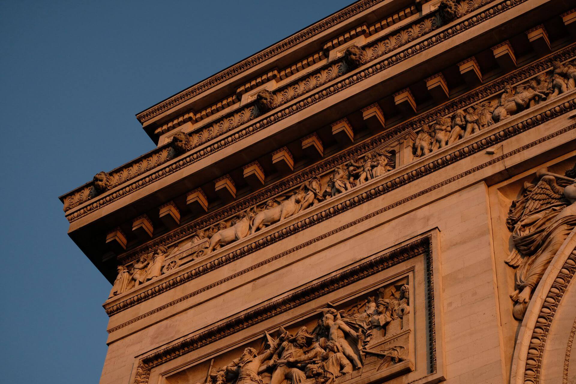 Basic Travel Tips to Make Your Paris Experience Great Detail of Arc de Triomph in Paris during golden hour