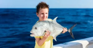 Boy with a fish on a reef fishing tour in Vilamoura